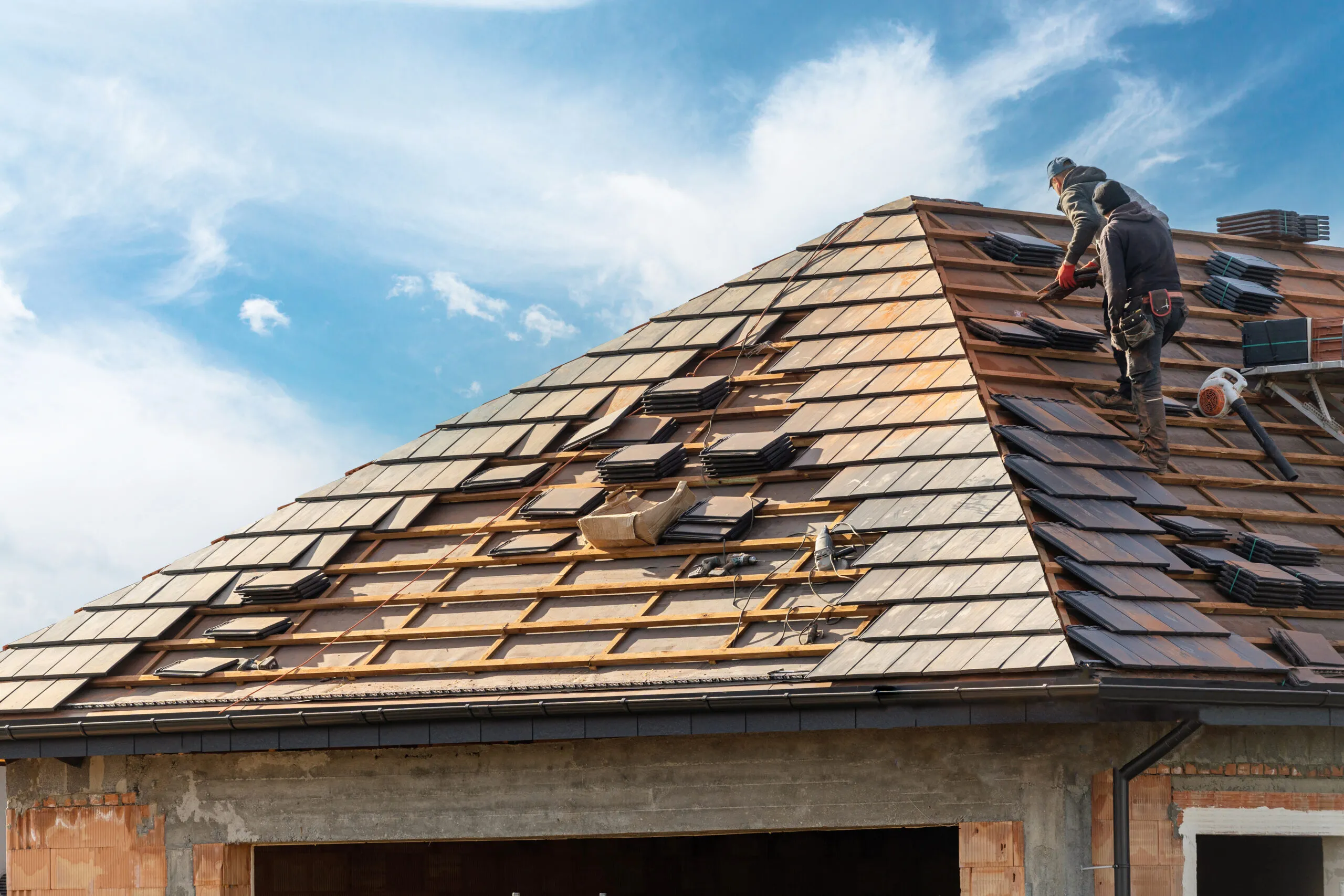 builder working on rooftop of house on construction site.